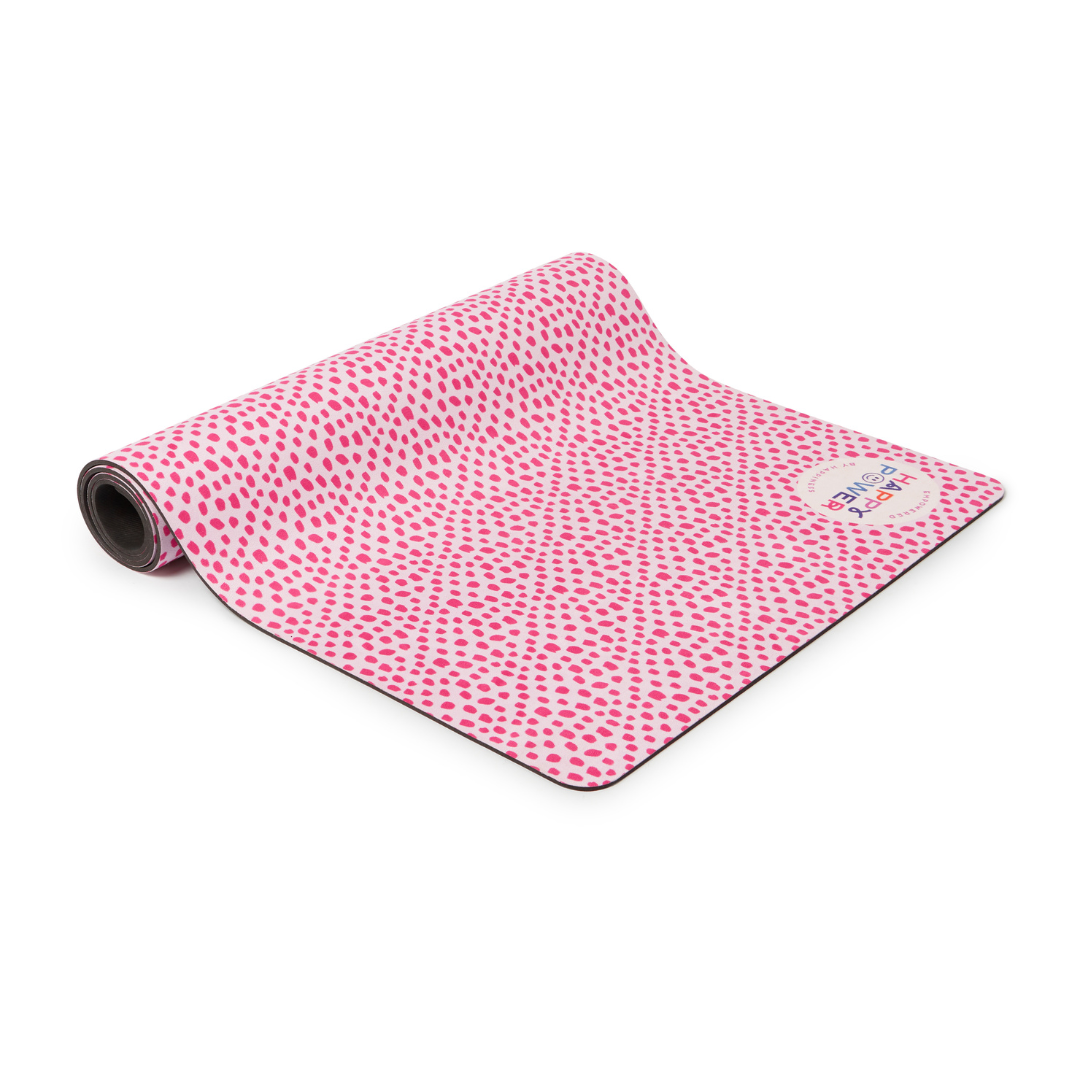 Eco friendly exercise and yoga mat with vegan suede top and natural rubber basefeaturing Bright pink dots on a pale pink background with a blue spot, a pink spot and pink petals. This mat can be used for workouts, yoga, pilates, stretching, meditation and more.